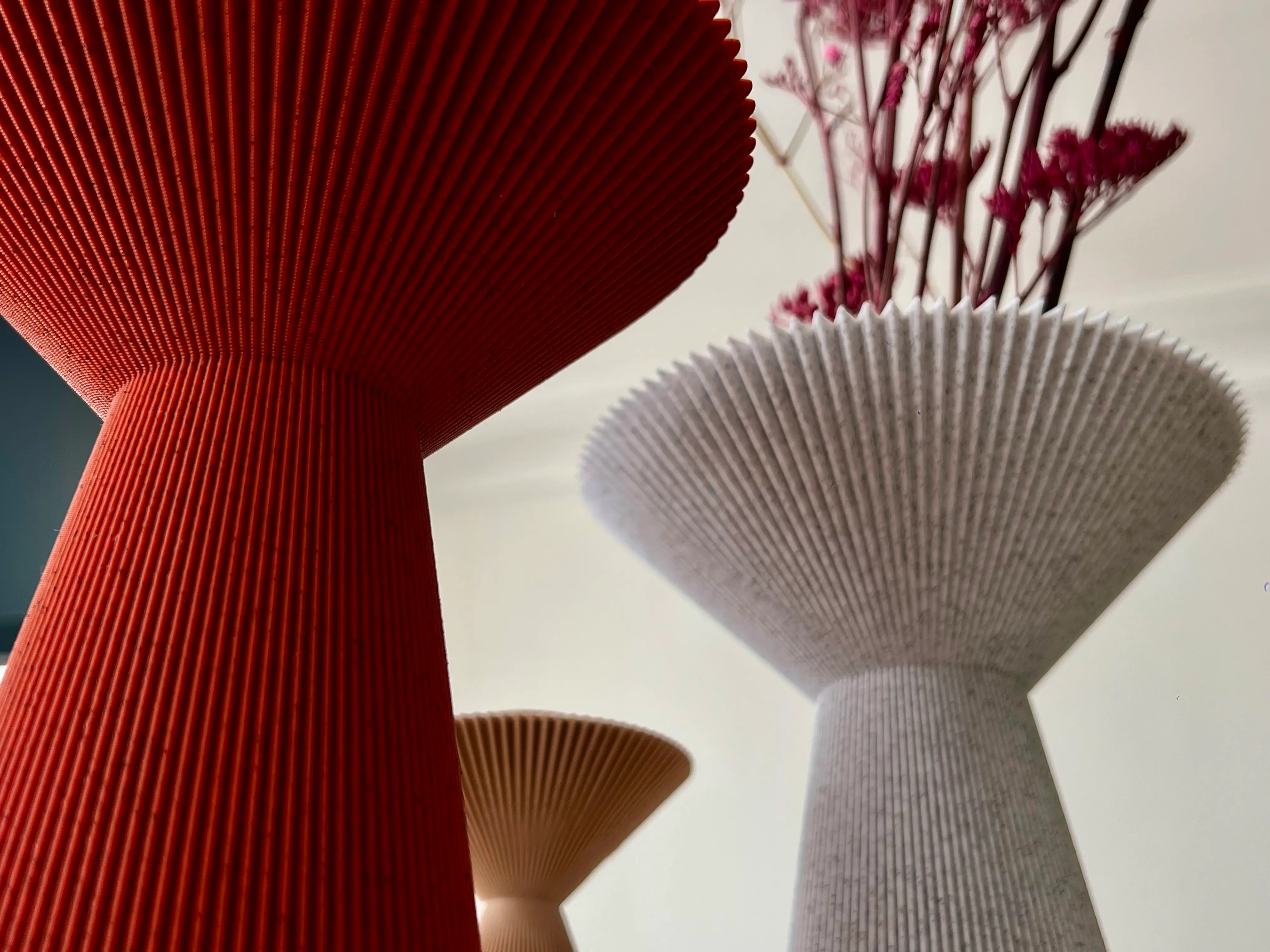 Vases Fold blanc moucheté et rouge vermillon, surfaces plissées vues en contre-plongée